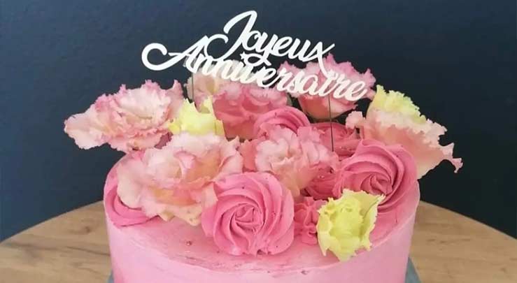 Gâteau d'anniversaire de couleur rose avec des fleurs